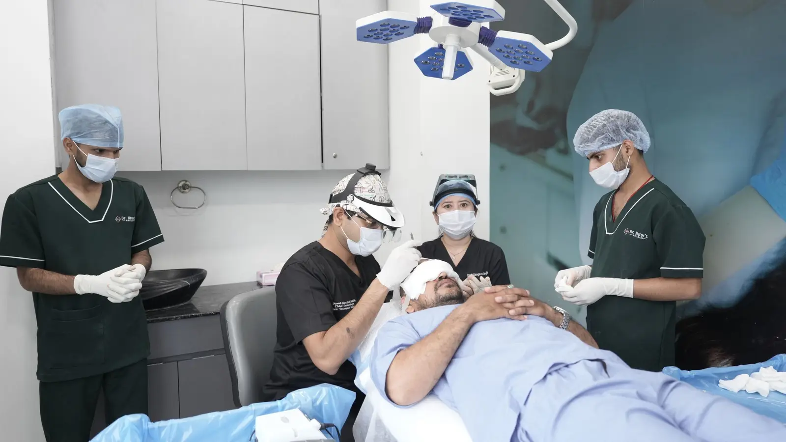 צוות רפואי מבצע השתלת שיער בחדר טיפולים: הרופא עם משקפי הגדלה עובד על הקרקפת של המטופל
